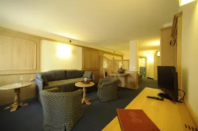 a living room with a couch and a tv at Family Hotel Andes - Only for Family in Vigo di Fassa
