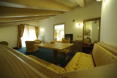 a living room with a wooden table and chairs at Family Hotel Andes - Only for Family in Vigo di Fassa