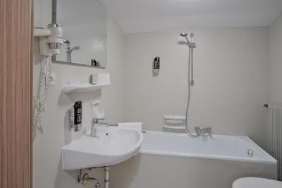 a white bathroom with a sink and a bath tub at Almarett in Racines
