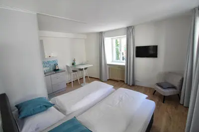 a bedroom with two beds and a desk and a window at Maria von Buol - Wohnen in Kaltern in Caldaro