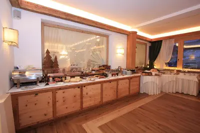 a buffet line with food on it in a room at Hotel Trieste in Cortina dʼAmpezzo