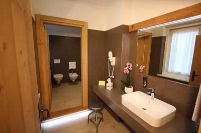 a bathroom with a sink and a mirror at Hotel Trieste in Cortina dʼAmpezzo