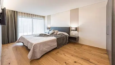 a bedroom with a bed and a large window at Penthouse Skygarden in Schenna