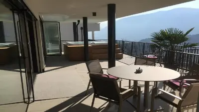 a balcony with a table and chairs and a tub at Penthouse Skygarden in Schenna