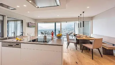 a kitchen and dining room with a table and chairs at Penthouse Skygarden in Schenna