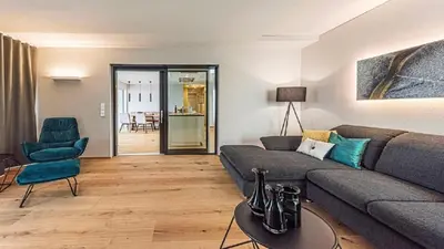 a living room with a couch and a chair at Penthouse Skygarden in Schenna