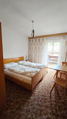 a bedroom with a large bed and a window at Appartamenti Bernard Sas in Canazei