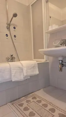 a bathroom with a sink and a shower with towels at Appartamenti Bernard Sas in Canazei