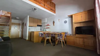 a kitchen with a table and chairs in a room at Appartamenti Bernard Sas in Canazei