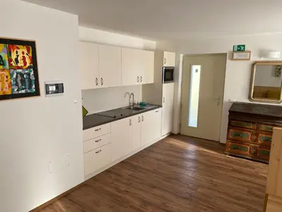 an empty kitchen with white cabinets and a sink at Brentwaldhof Appartements in Cornedo all'Isarco