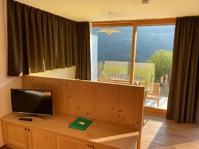 a living room with a television on a wooden table at Brentwaldhof Appartements in Cornedo all'Isarco