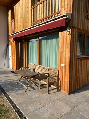 a patio with a bench and a table on a building at Brentwaldhof Appartements in Cornedo all'Isarco