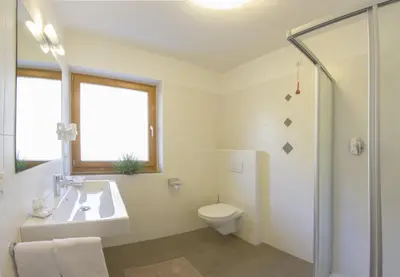 a white bathroom with a sink and a toilet at Residence *** Geringerhof in Schenna