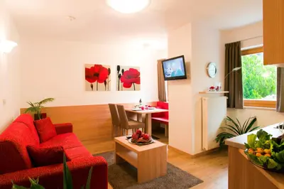 a living room with a red couch and a table at Residence *** Geringerhof in Schenna