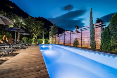 a swimming pool with chairs and umbrellas at a resort at Eggentaler in Bolzano