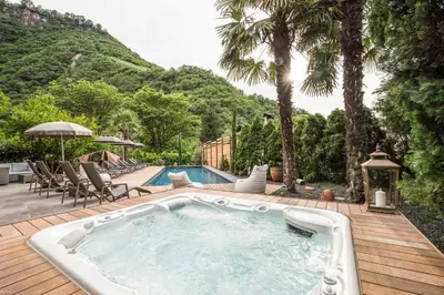 a swimming pool on a wooden deck next to a house at Eggentaler in Bolzano