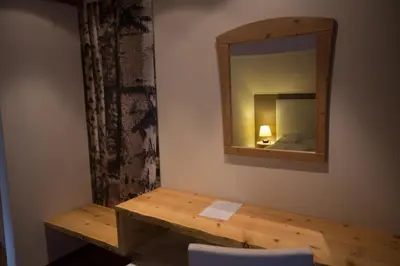 a room with a wooden table and a mirror at Eggentaler in Bolzano