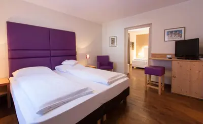a bedroom with a large bed with a purple headboard at Eggentaler in Bolzano