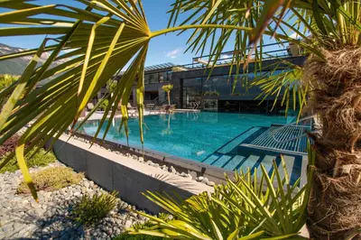 a large swimming pool next to a building at Weinegg Wellviva Resort in Appiano sulla Strada del Vino