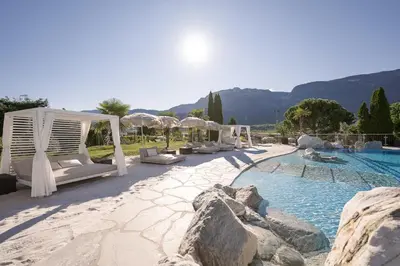 a pool with lounge chairs and a resort at Weinegg Wellviva Resort in Appiano sulla Strada del Vino