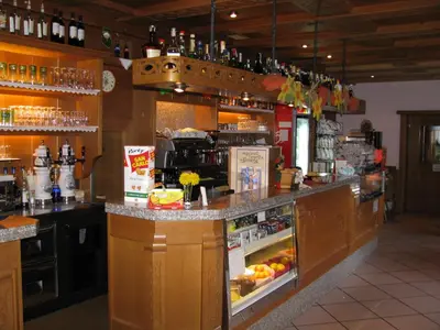 a kitchen with a bar with an open refrigerator at Hotel Ladina in Campitello di Fassa