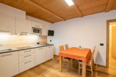 a kitchen with a table and chairs in a room at Piz da Cir in Colfosco