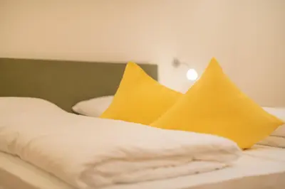 a bed with yellow pillows on top of it at Piz da Cir in Colfosco