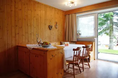 a kitchen with a table and chairs and a window at Piz da Cir in Colfosco