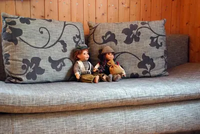 two dolls sitting on top of a couch at Piz da Cir in Colfosco