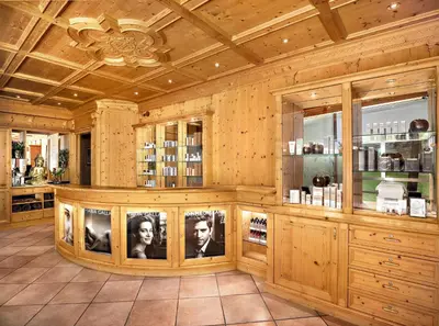 a room with a wooden wall with pictures of two people at Hotel Alpenroyal - The Leading Hotels of the World in Selva di Val Gardena