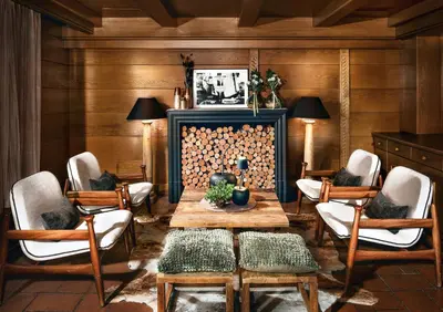 a living room with a table and chairs and a fireplace at Hotel Alpenroyal - The Leading Hotels of the World in Selva di Val Gardena