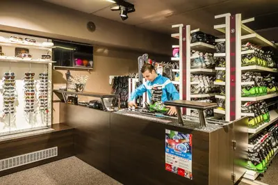 a woman standing at a counter in a store at Hotel Alpenroyal - The Leading Hotels of the World in Selva di Val Gardena