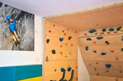 a boy on a climbing wall in a climbing gym at Pension Tasa in Valles