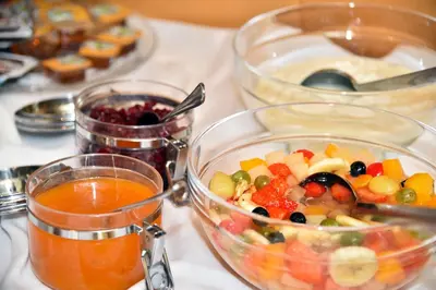 a table with two containers of food and a bowl of fruit at Pension Tasa in Valles