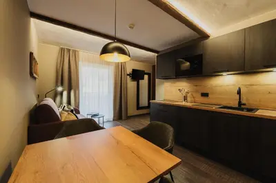a book on a bed with pillows and a lamp at TANOVINUM Apartments in Villandro