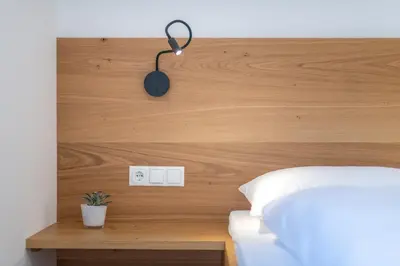 a bedroom with a wooden headboard with a lamp on it at Pension Gruenwald in Andrian