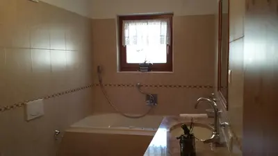 a bathroom with a bath tub and a window at Family and Wellness Residence Ciasa Antersies in San Cassiano
