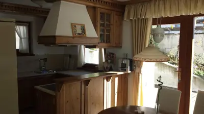 a kitchen with wooden cabinets and a counter top at Family and Wellness Residence Ciasa Antersies in San Cassiano