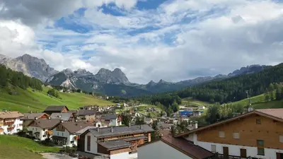 a town in a valley with mountains in the background at Family and Wellness Residence Ciasa Antersies in San Cassiano