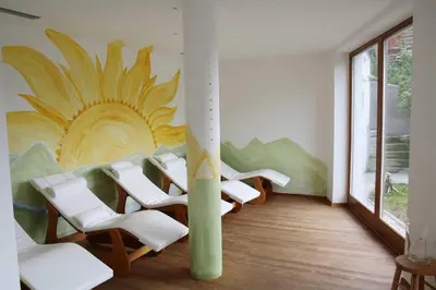 a room with chairs and a mural of a sunflower at Family and Wellness Residence Ciasa Antersies in San Cassiano