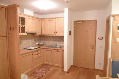 a kitchen with wooden cabinets and a sink at Family and Wellness Residence Ciasa Antersies in San Cassiano
