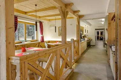 a large kitchen with wooden cabinets and a wooden railing at Hotel Garni Lastei in Pozza di Fassa