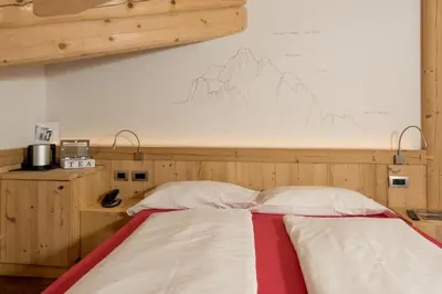 a bed with two white pillows in a room at Hotel Garni Lastei in Pozza di Fassa
