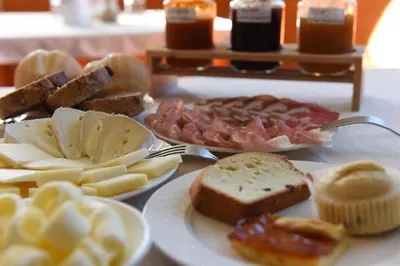 a table with different types of food on plates at Agritur Maso Chemela in Cavalese