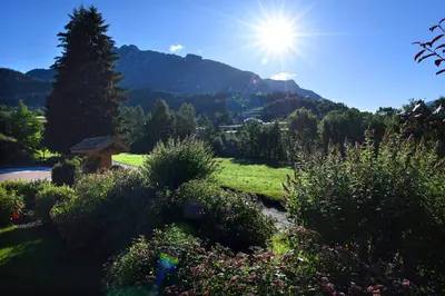 a view of a garden with the sun in the sky at Agritur Maso Chemela in Cavalese