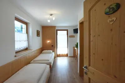 a hospital room with two beds and a window at Agritur Maso Chemela in Cavalese