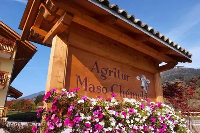 a sign for a masoco chianti resort with flowers at Agritur Maso Chemela in Cavalese