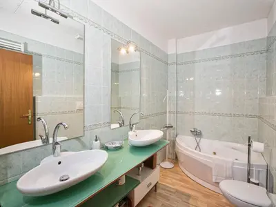 a bathroom with two sinks and a tub at Apartment in Predazzo near Dolomiti Superski in Predazzo