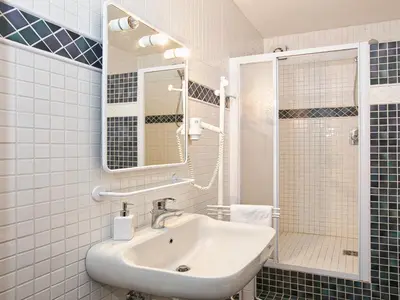 a white bathroom with a sink and a shower at Apartment in Predazzo near Dolomiti Superski in Predazzo