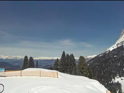 a snow covered slope with trees and mountains in the background at Apartment in Predazzo near Dolomiti Superski in Predazzo